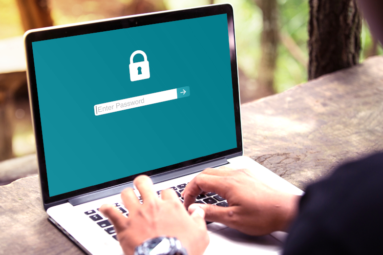 Symbolfoto Cybersicherheit: Laptop mit Eingabemaske eines Passworts und Händen auf Tastatur