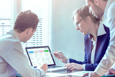 Symbolfoto agile Methoden: 3 Personen schauen auf Bildschirm mit agilen Produktentwicklungs-Board