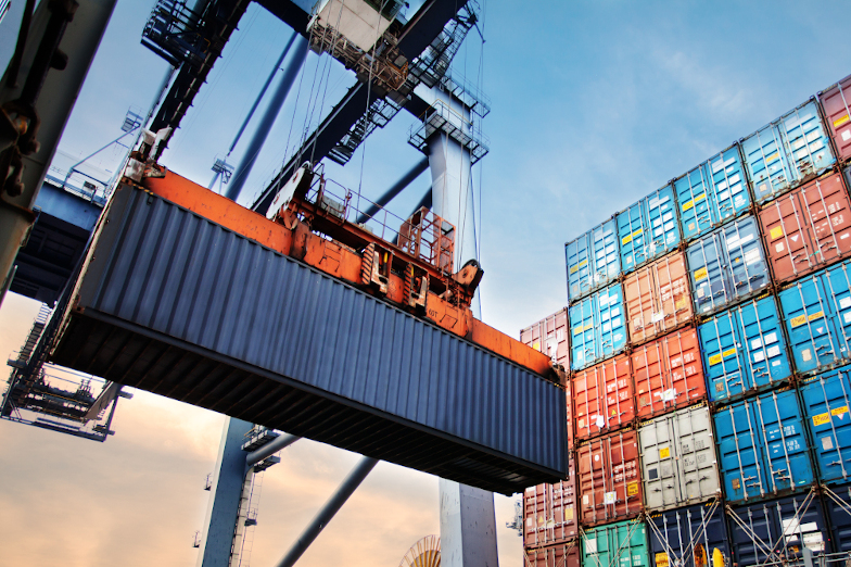 Frachtkran im Containerhafen beim Beladen eines Schiffes.