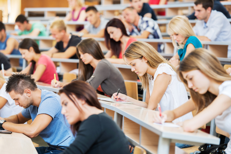 Symbolbild Bachelor-Studiengang Wirtschaftsinformatik: Studierende in einem Hörsaal schreiben eine Klausur.
