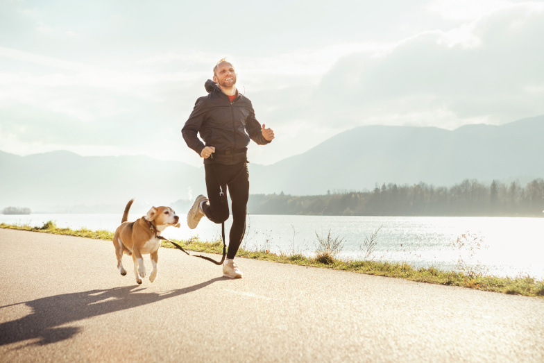 Symbolbild Work-Life-Balance: Fröhlicher Mann joggt mit seinem Hund, einem Beagle. (Quelle: Adobe Stock / Soloviova Liudmyla) Symbolbild Work-Life-Balance: Fröhlicher Mann joggt mit seinem Hund, einem Beagle.