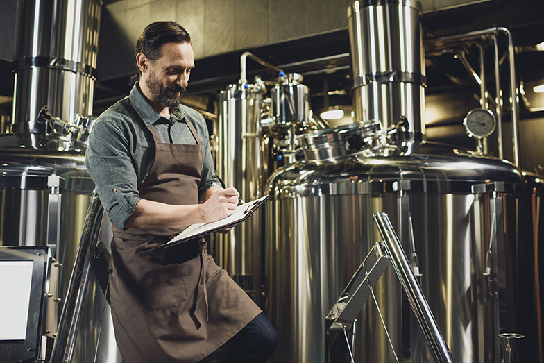 Destillateur prüft Anlagen in einer Brauerei.